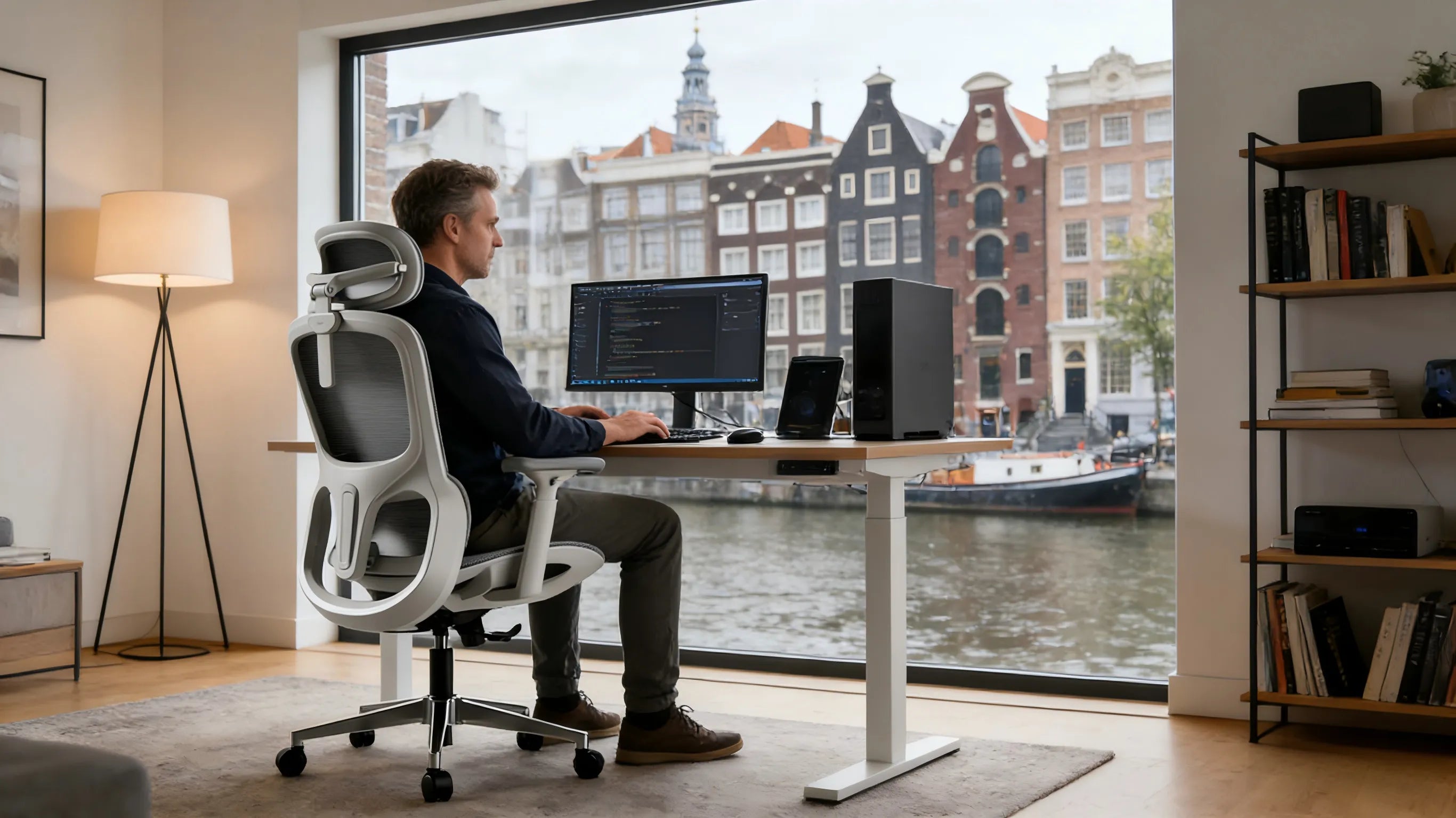 A professional software architect in an Amsterdam studio using a white-framed ergonomics office chair.
