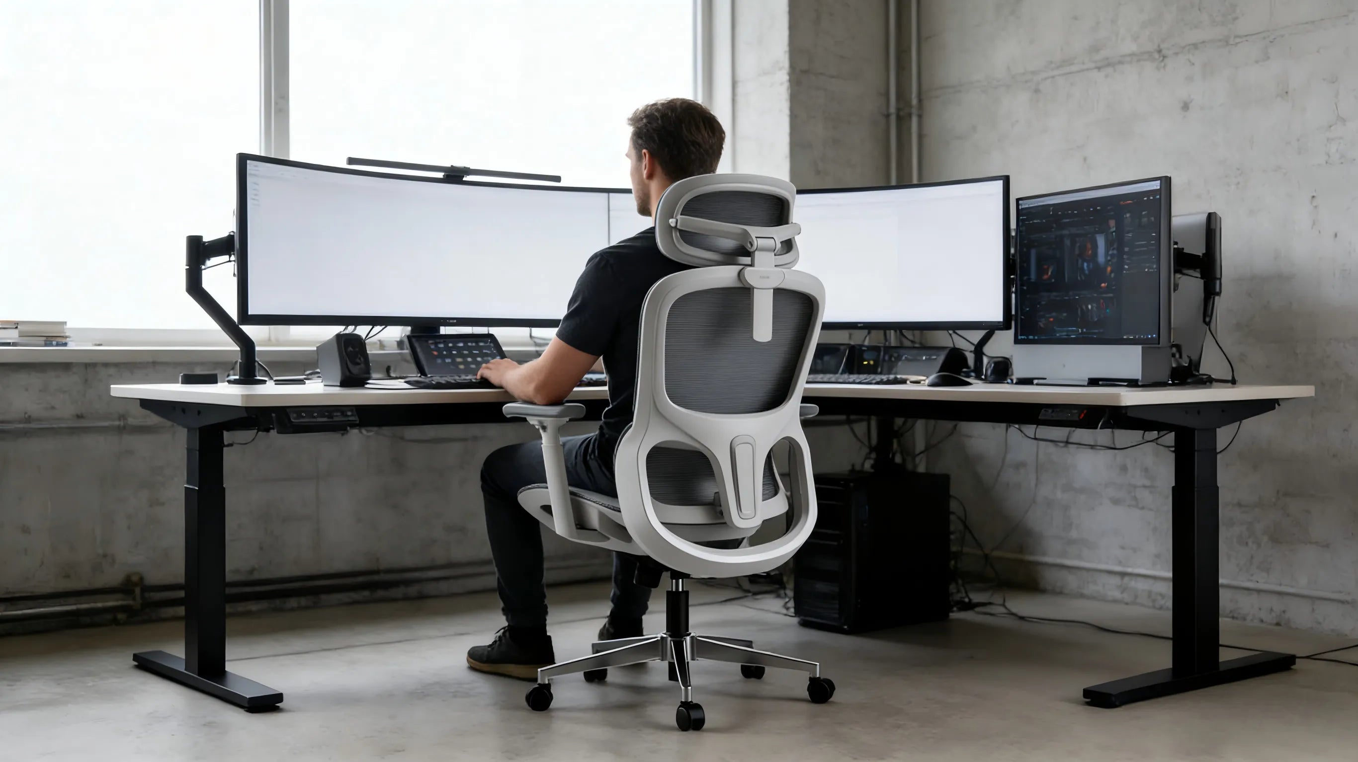 A professional UX designer in a Berlin studio using a white-framed ergo chair at a tech-heavy desk.