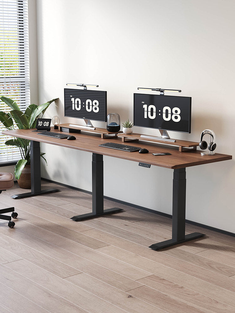 Extra-wide triple-motor standing desk with black legs and walnut top