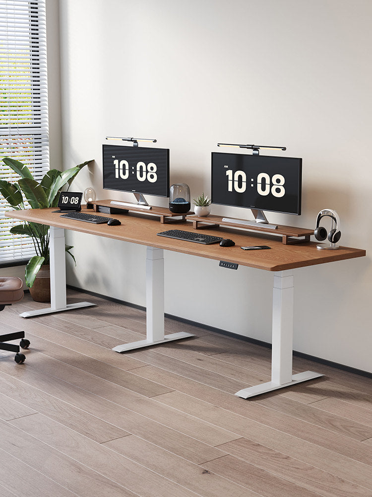 Extra-wide triple-motor standing desk with white legs and walnut top