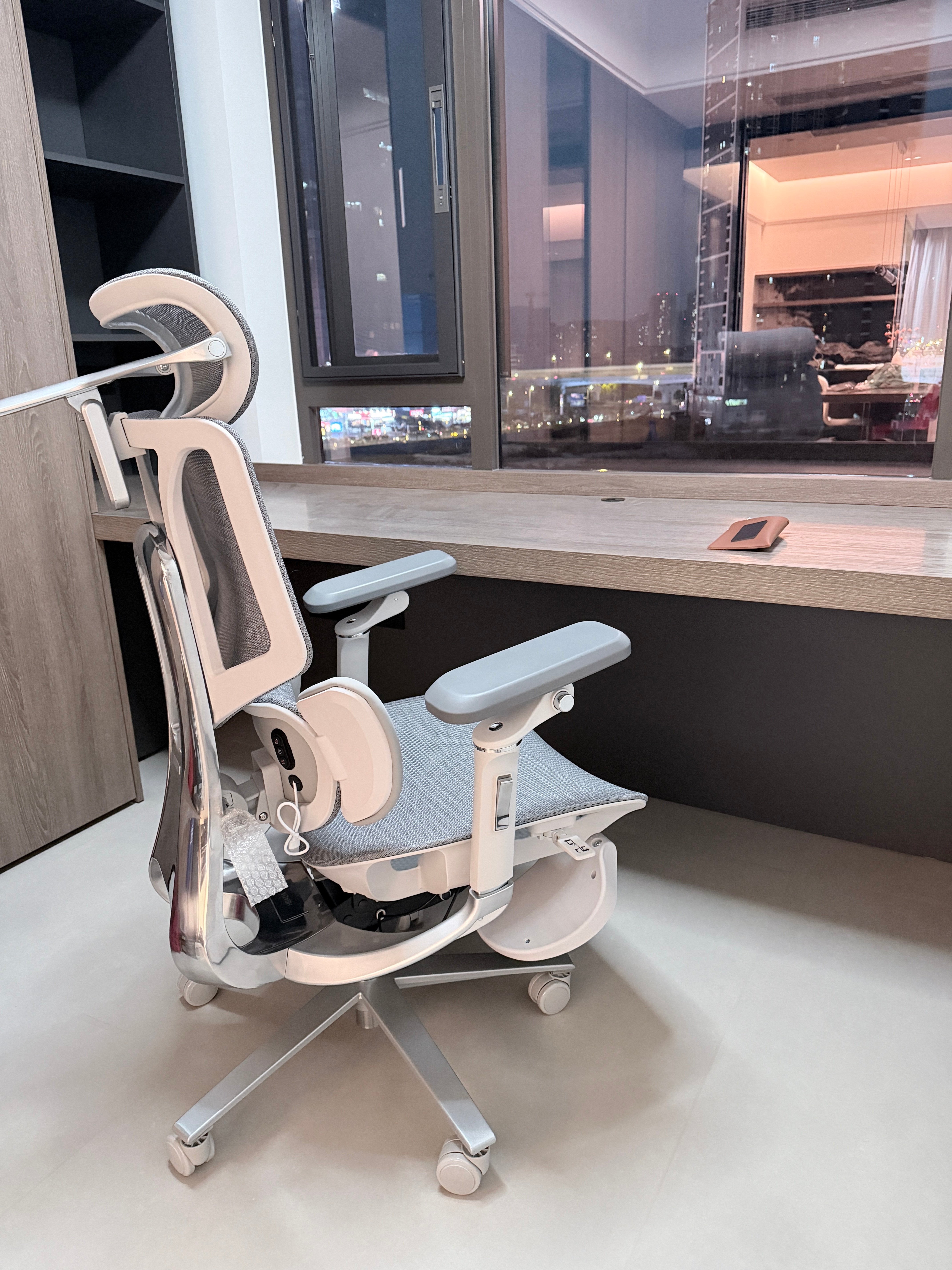 A side view showing seat height and depth adjustment levers on a fully functional ergonomic office chair.