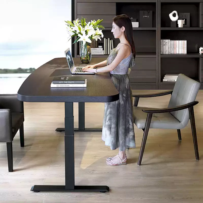Black oak dual-motor electric standing desk adjusted for standing work