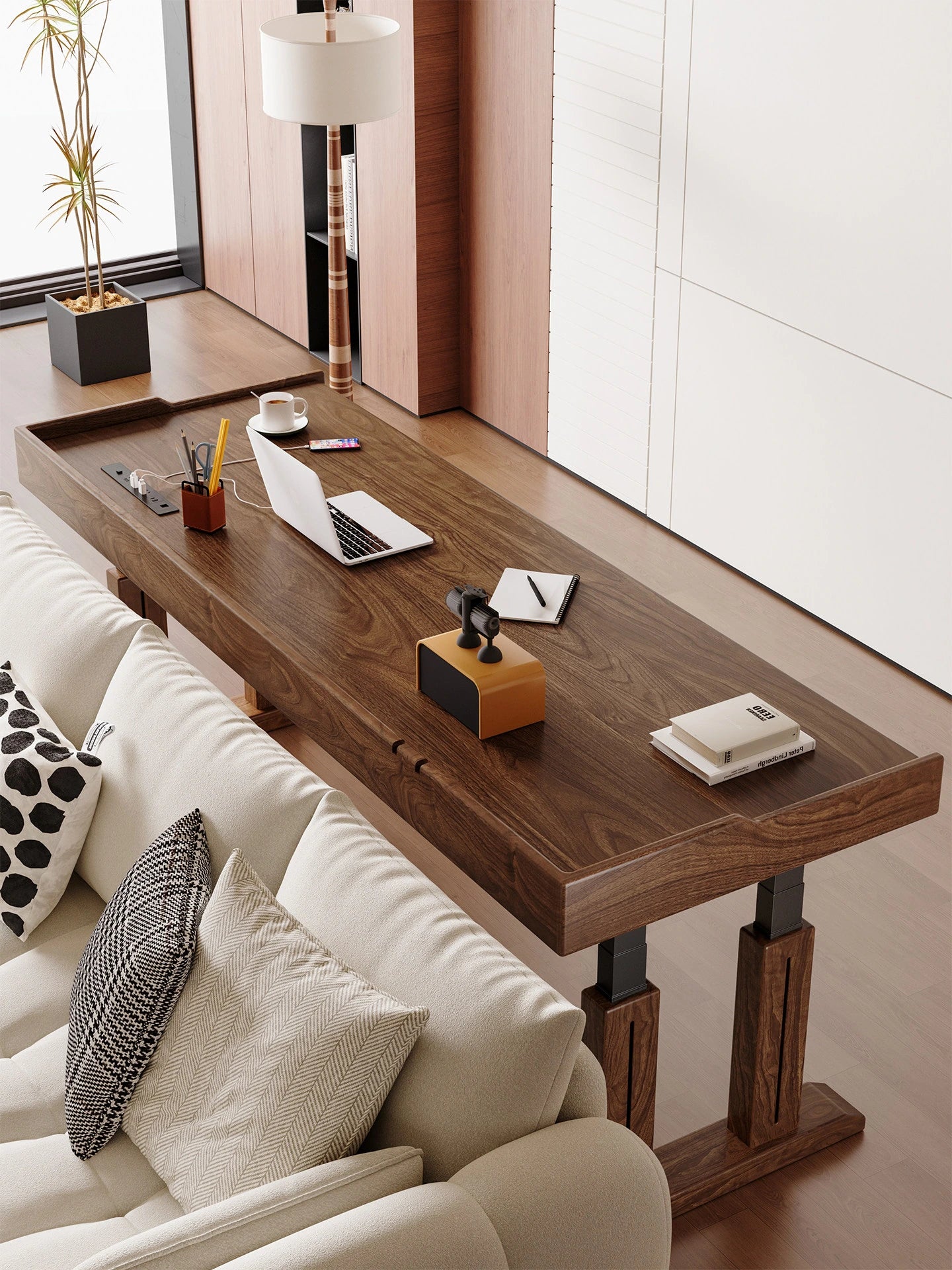 Extra-long solid wood electric standing desk behind a living room sofa