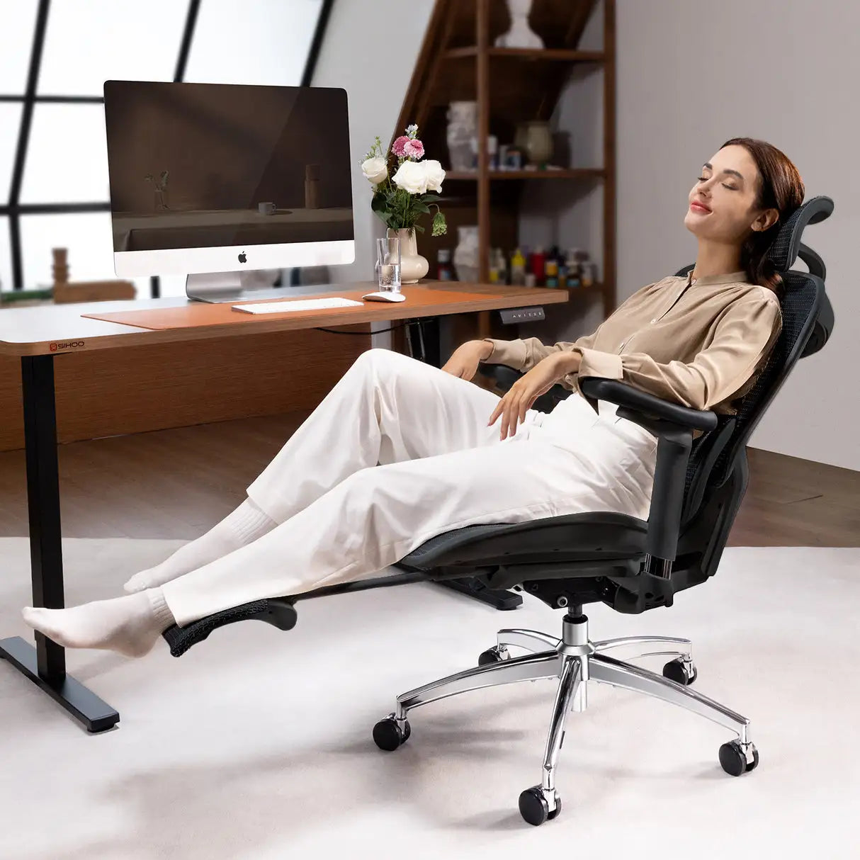 Space-saving gray mesh ergonomic office chair with flip-up arms and a hideaway leg rest for compact home offices.